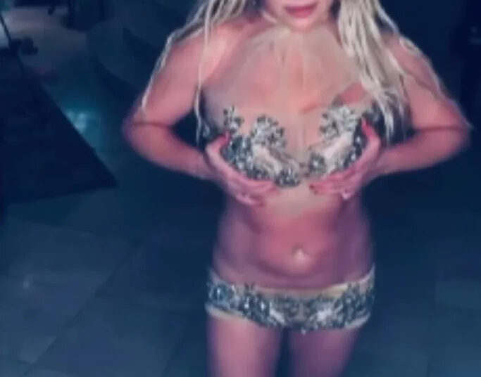 Britney Spears mostra sua barriga tonificada em um look minicurto