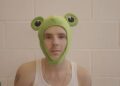 Cruz Beckham veste um colete e um peculiar chapéu de sapo enquanto a namorada Jackie Apostel se junta a ele no bizarro novo videoclipe do single de estreia Lick The Toad