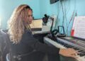 Jennette Jay Booth compõe músicas em seu teclado em casa em maio de 2023.