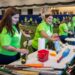 Os membros da equipe do Commerce Bank limpam e classificam o doado de equipamentos de beisebol e softball em 28 de agosto.