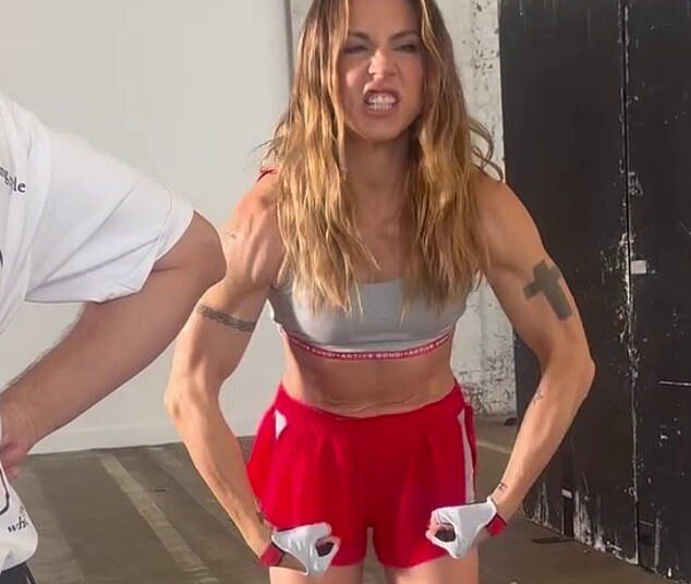 Spice Girl Mel C, 51, exibe seus abdominais e bíceps esculpidos enquanto flexiona os músculos em um clipe para anunciar o lançamento de sua última música, Sweat