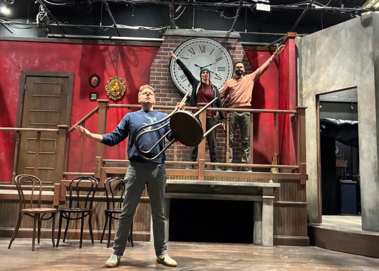 Adam Archer (nível inferior), Christina Cusack-Curbelo (da esquerda na plataforma) e Josh Quinn ensaiam para "Muito rápido, muito festivus," uma coprodução Dad's Garage e Horizon Theatre Company. (Cortesia da Garagem do Papai)