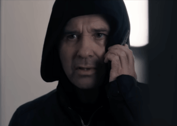 Andrew Scarborough como Graham Foster em um moletom preto e ao telefone em Corriedale.