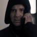 Andrew Scarborough como Graham Foster em um moletom preto e ao telefone em Corriedale.