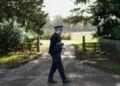 Um policial monta guarda na entrada de Wood Farm, na propriedade da família real Sandringham, em Norfolk, leste da Inglaterra, em 22 de fevereiro de 2026, depois que o ex-príncipe britânico Andrew foi preso em 19 de fevereiro.