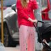 Jennifer Lawrence combina vermelho e rosa em um carrinho com seu filho bebê
