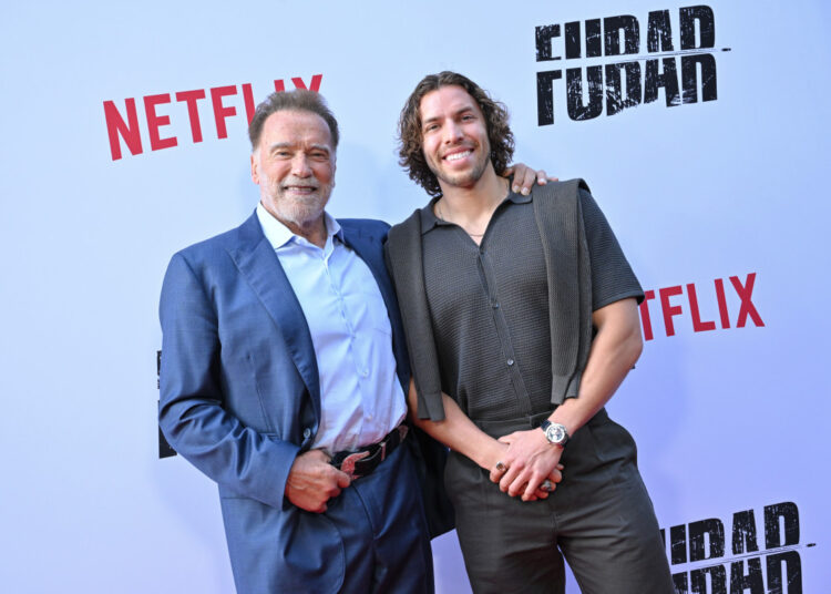 O filho de Arnold Schwarzenegger, Joseph Baena, ostenta uma espada e uma sunga para vencer a segunda competição de fisiculturismo