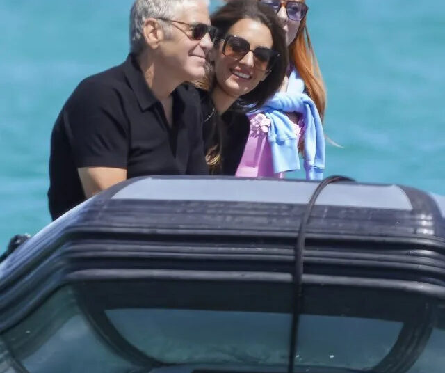 George Clooney e sua esposa Amal sorriem de braços dados na água na França para comemorar seu 65º aniversário