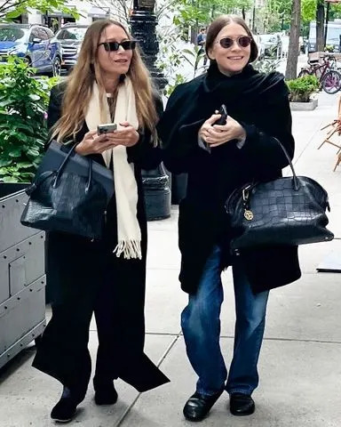 Mary-Kate e Ashley Olsen sorriem enquanto usam looks que combinam