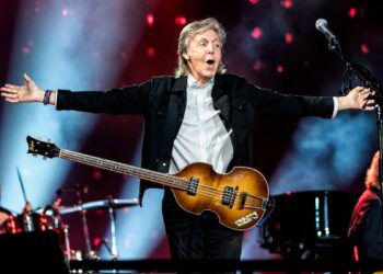 Paul McCartney con los brazos abiertos y el bajo colgando