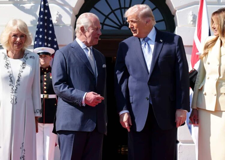 King Charles III and Donald Trump stand together on a red carpet outdoors, flanked by Queen Camilla and Melania Trump.
