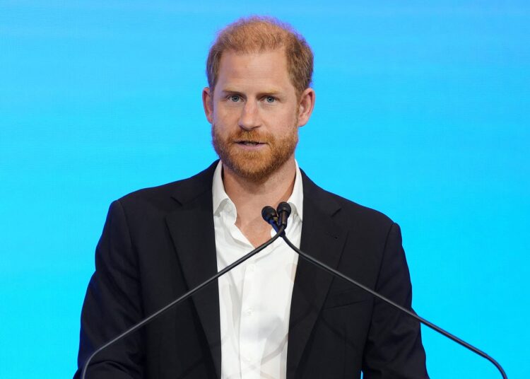 El príncipe Harry habla en un podio
