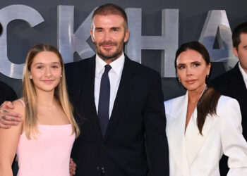 David y Victoria Beckham con sus hijos en un evento. David lleva traje y Victoria viste un traje blanco.