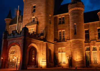 The castle is lit by orange lighting, it is dark outside.