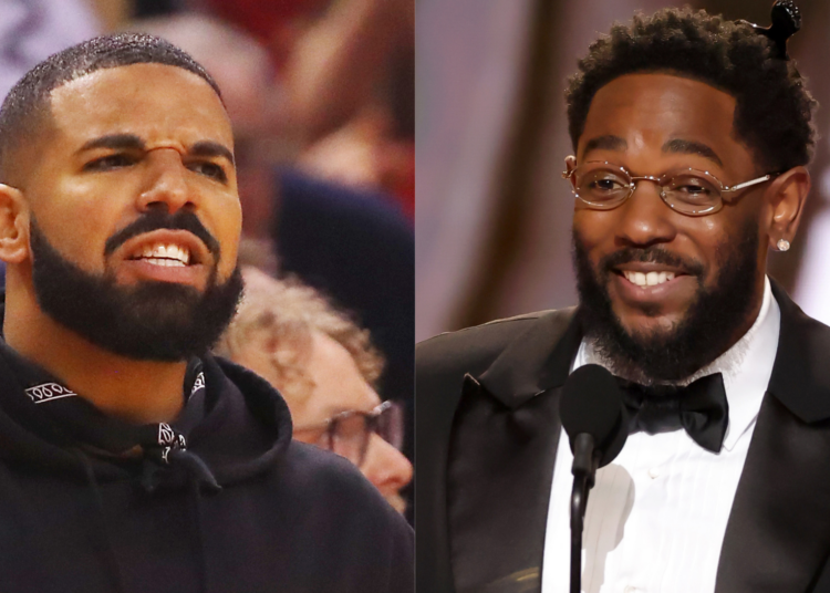 Drake on the left, wearing a hoodie, and Kendrick Lamar on the right, in a tuxedo with glasses, speaking at a microphone.