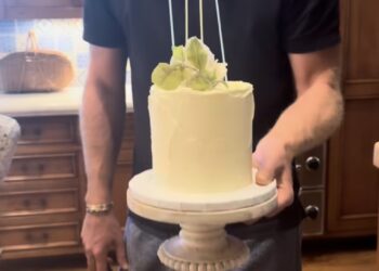 El Príncipe Harry sosteniendo su pastel de aniversario.