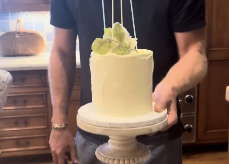El Príncipe Harry sosteniendo su pastel de aniversario.