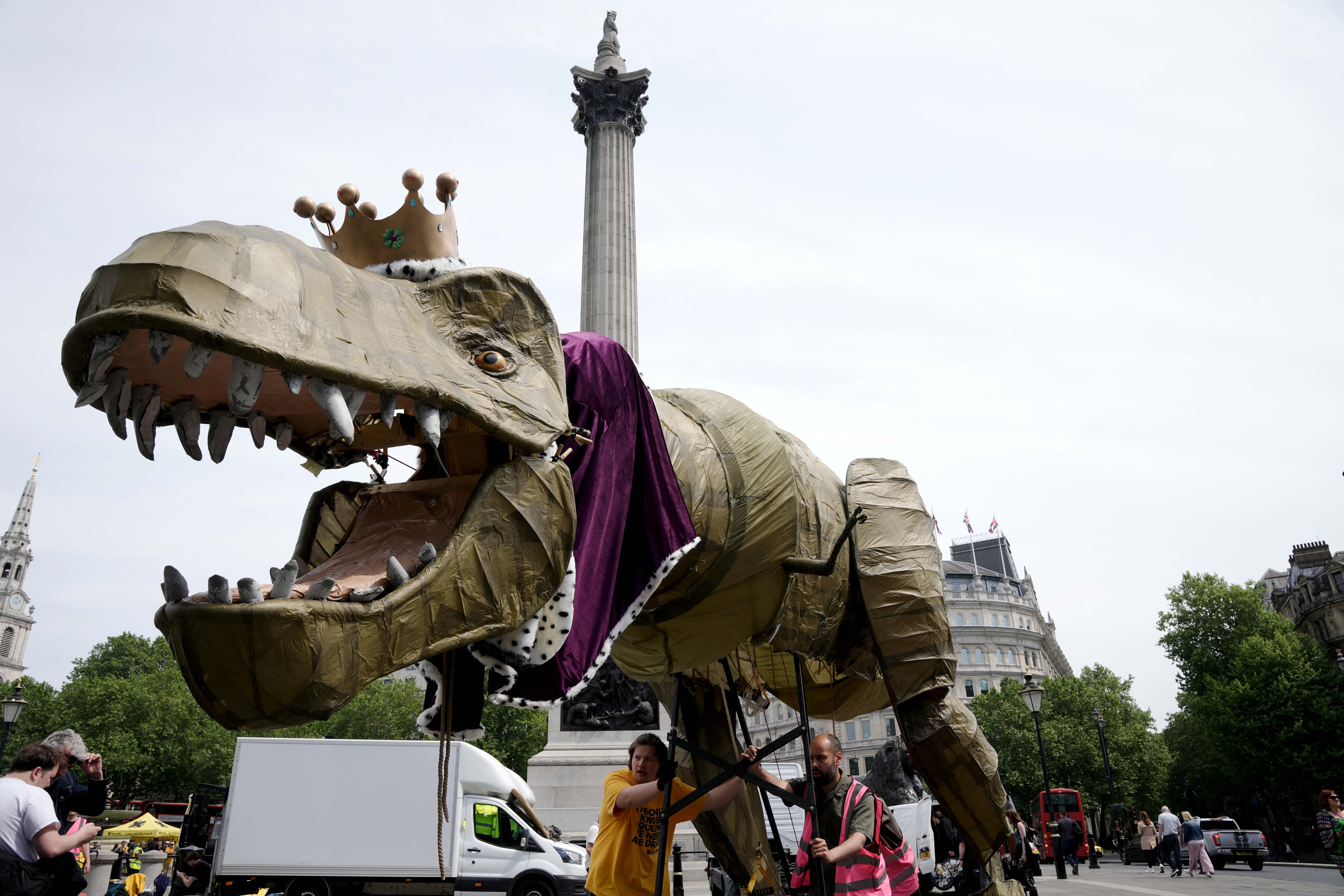 La gente participa en una marcha organizada por el grupo de presión antimonárquico Republic, acompañada por una mascota dinosaurio de cinco metros llamada Chuck el Rex, desde Trafalgar Square hasta el Palacio de Buckingham.