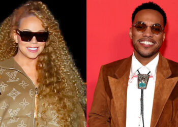 Mariah Carey con un conjunto de Louis Vuitton con gafas de sol, y Anderson .Paak con un traje marrón con corbata tipo bolo, ambos sonriendo.