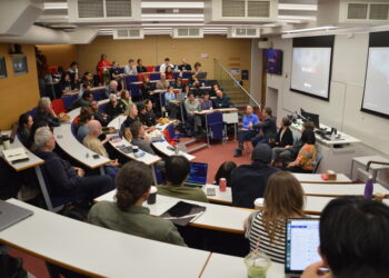 Grupo de académicos y estudiantes escuchando un panel