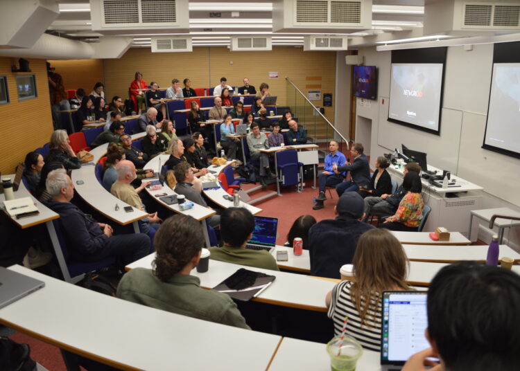 Grupo de académicos y estudiantes escuchando un panel