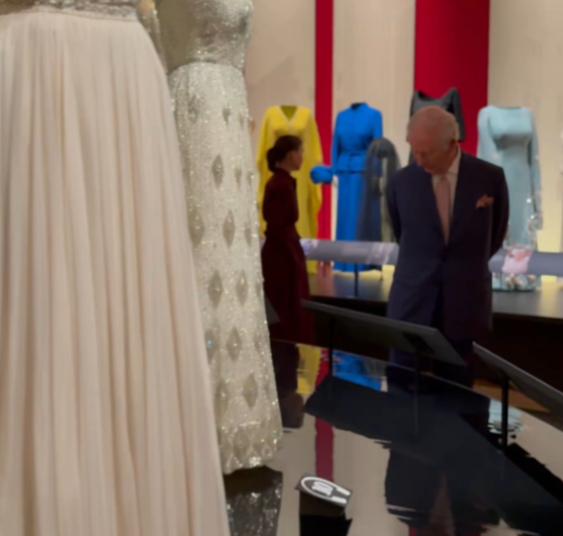 El rey Carlos mira la ropa de la reina Isabel II