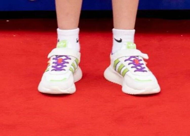 Unas zapatillas blancas sobre una deslumbrante alfombra roja