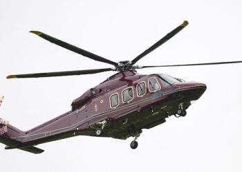 Un helicóptero de color violeta oscuro en el cielo.