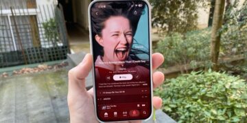 Una mano sosteniendo un iPhone donde se muestra el último álbum de Sigrid en Apple Music