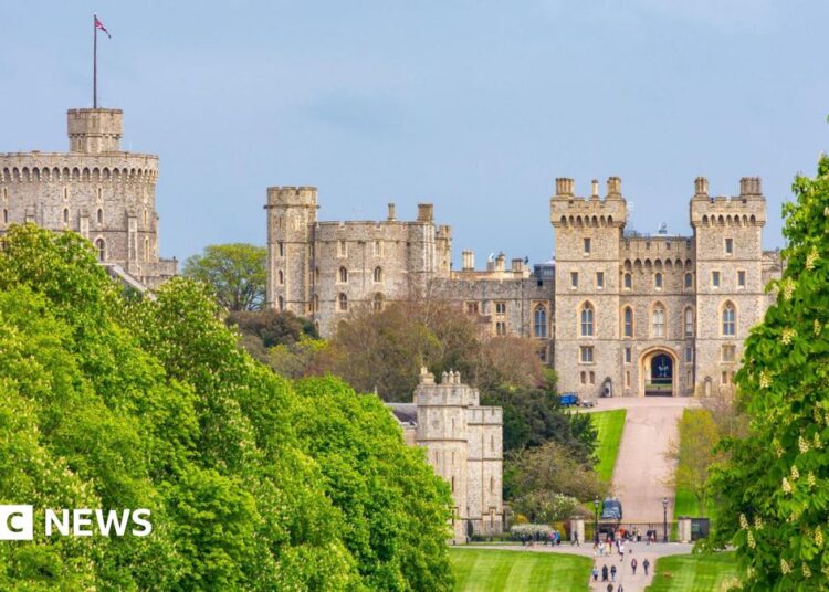A general view picture of Windsor Castle, with the entrance gates and people stood outside them at the bottom of the picture.