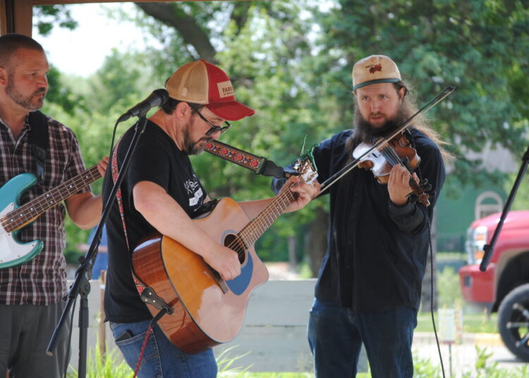 Jeff Vetsch, centro, y Todd Anderson, izquierda, y Dempsey Schroeder, derecha, miembros de Jeff Vetsch and Friends, actúan como parte de la quinta edición anual de New London. "Fiesta del porche" el sábado 7 de junio de 2025.