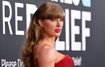 Taylor Swift posando en una alfombra roja.
