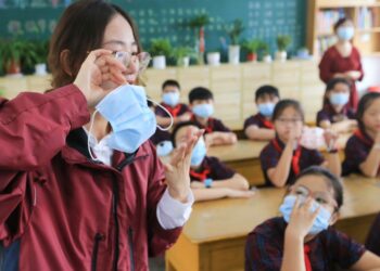 A primary school teacher shows her students how to properly wear a mask in Lianyungang city, eastern China's Jiangsu Province, on August 30, ahead of the official start of the new semester on September 1. On Friday, China's health authorities announced that the country's Delta variant outbreak has been