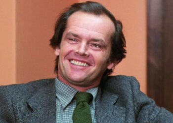 Jack Torrance de Jack Nicholson sonríe mientras está sentado en una oficina en El Resplandor
