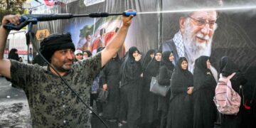 Las personas son rociadas con agua para refrescarse durante el calor mientras hacen cola para recibir comida en su camino a la Gran Mosalla en Teherán el 5 de julio de 2026, para las ceremonias fúnebres del asesinado líder supremo de Irán, el ayatolá Ali Jamenei. — Foto AFP