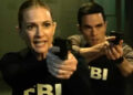 Two actors portraying FBI agents aim their guns intently in a tense scene from a TV show or movie