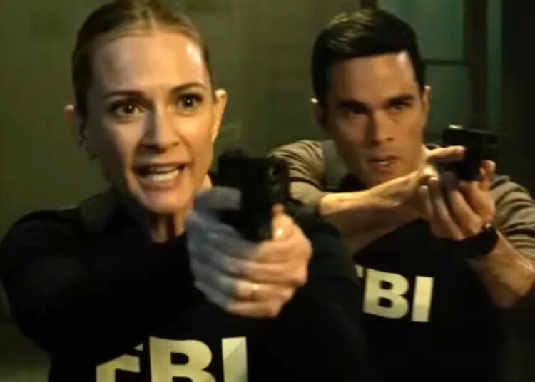 Two actors portraying FBI agents aim their guns intently in a tense scene from a TV show or movie