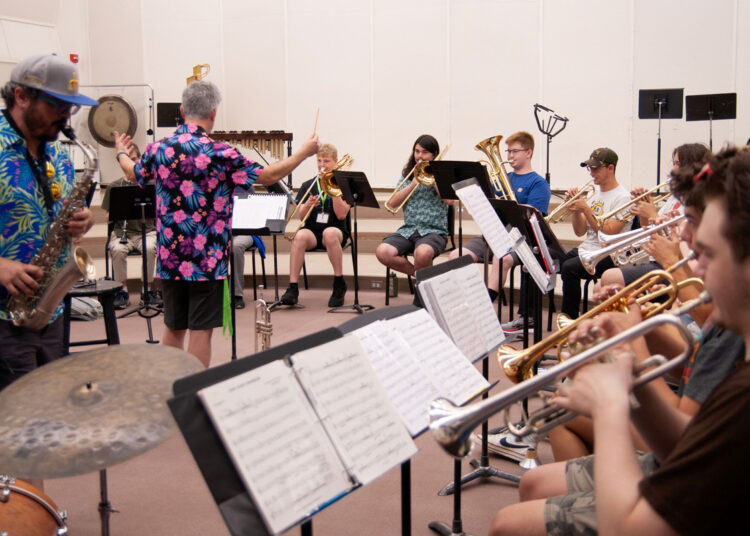 A director leading jazz musicians during a rehearsal.